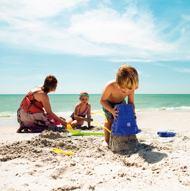 Bambini che giocano con la sabbia in spiaggia